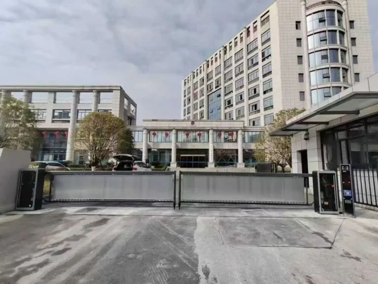 Commercial building entrance with sliding gate and access control system for managing vehicle entry and exit.