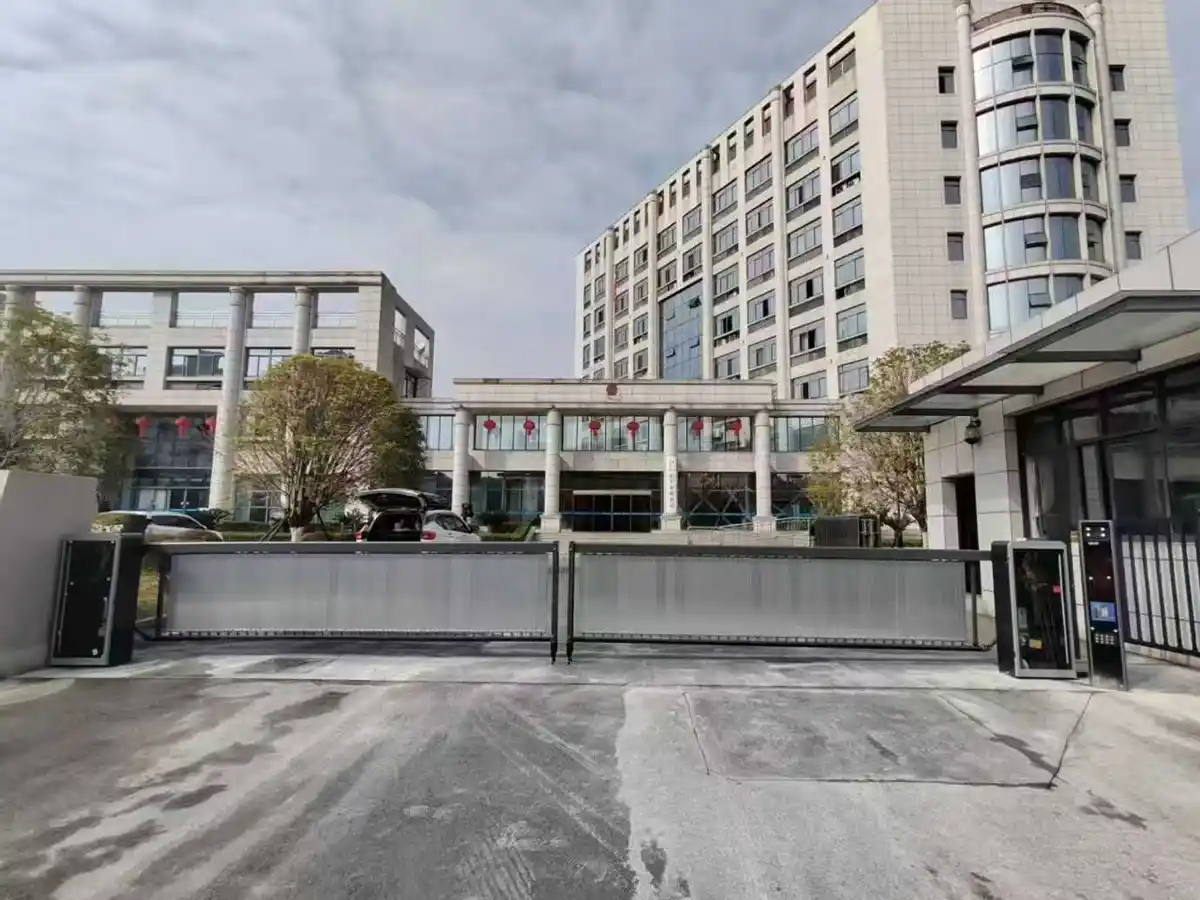 Commercial building entrance with sliding gate and access control system for managing vehicle entry and exit.