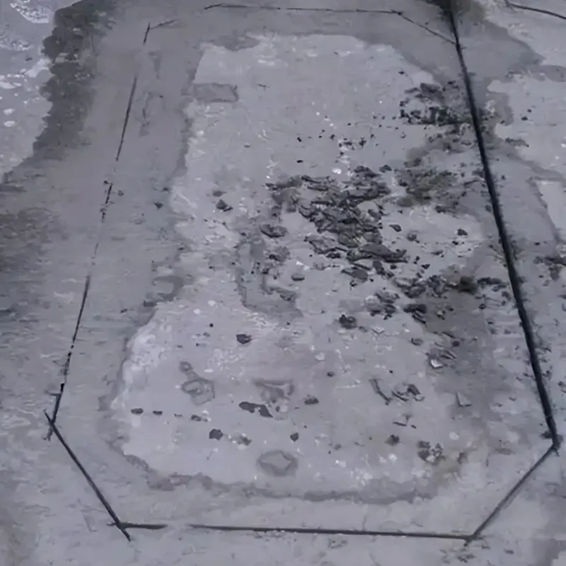 Pavement slot cut in a rectangular loop shape with beveled corners for ground sensing coil installation.