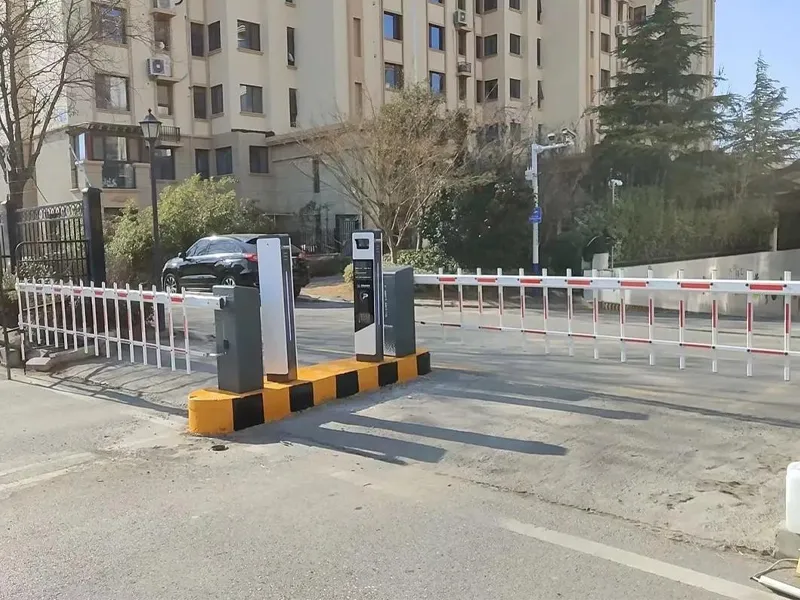 Residential parking entrance with automatic barrier gate and access control terminal